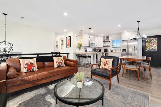 living room with a chandelier and light hardwood / wood-style flooring