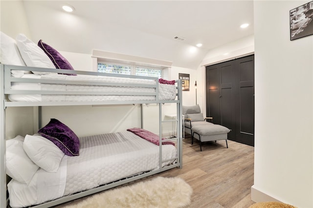 bedroom featuring vaulted ceiling and light wood-type flooring