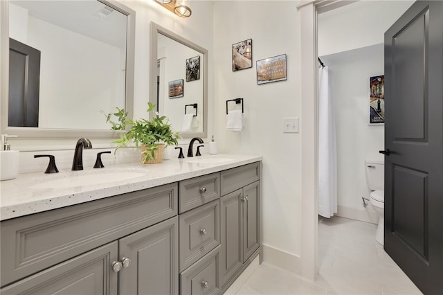 bathroom featuring vanity, tile patterned floors, and toilet