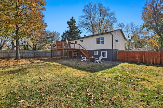 rear view of property featuring a lawn and a deck