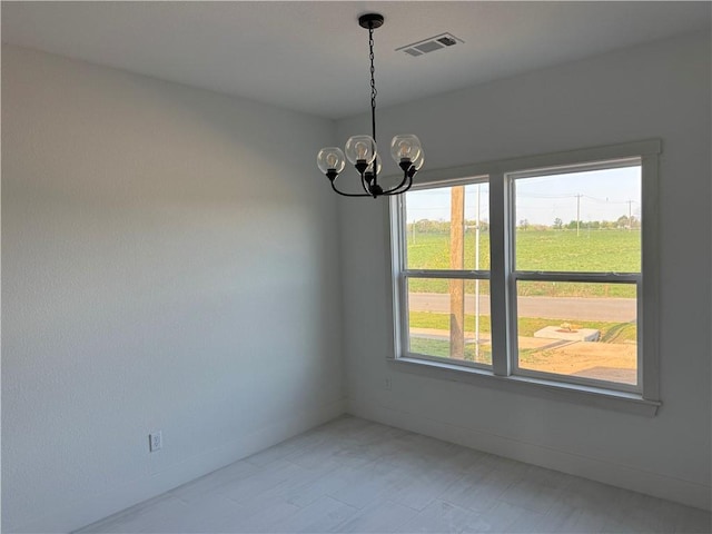 unfurnished room with baseboards, a notable chandelier, and visible vents