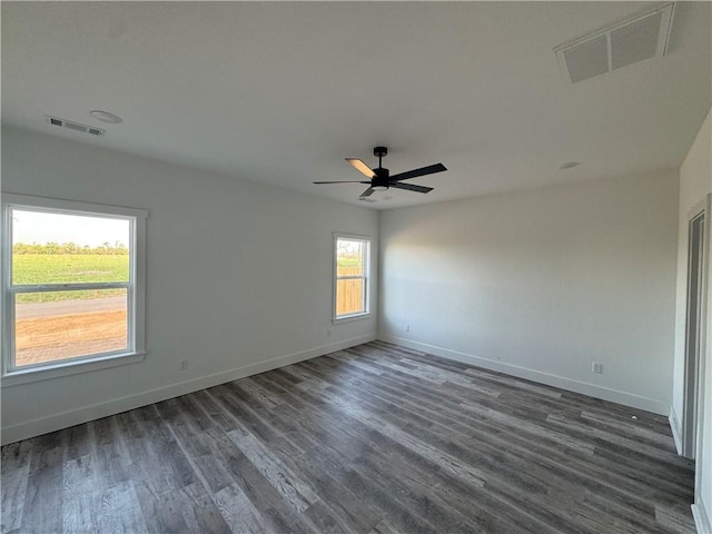 spare room featuring baseboards, a ceiling fan, wood finished floors, and visible vents