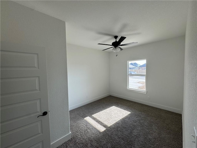 carpeted empty room with baseboards and ceiling fan