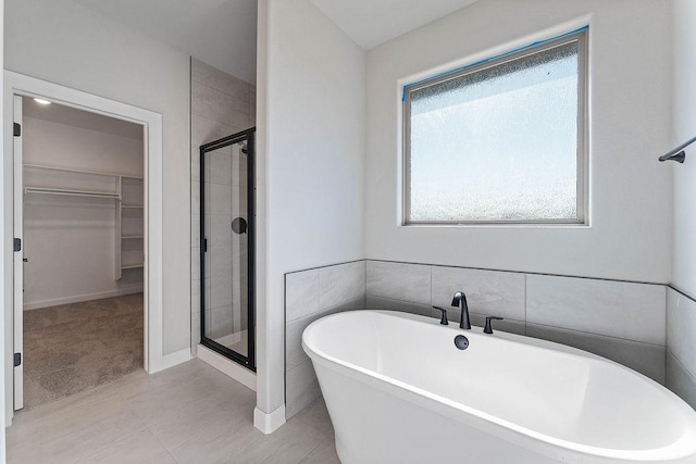 1440 Tiffany St, Centerton, AR 72719 - bathroom featuring a spacious closet, a stall shower, a soaking tub, and tile patterned floors