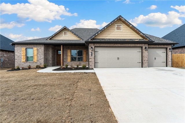 view of front facade with brick siding, fence, roof with shingles, driveway, and an attached garage