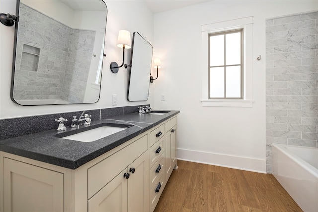 full bathroom with double vanity, wood finished floors, baseboards, and a sink