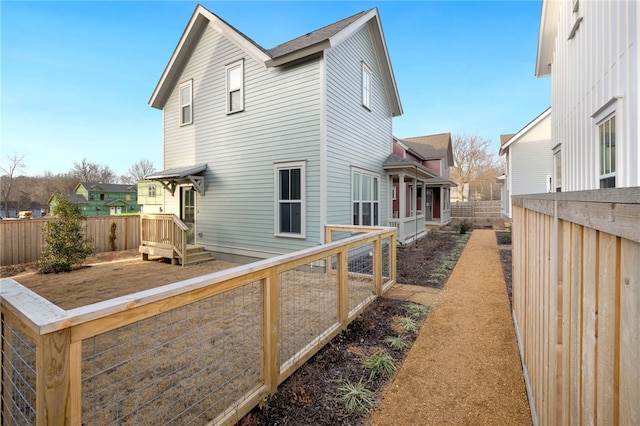 rear view of house featuring a fenced backyard