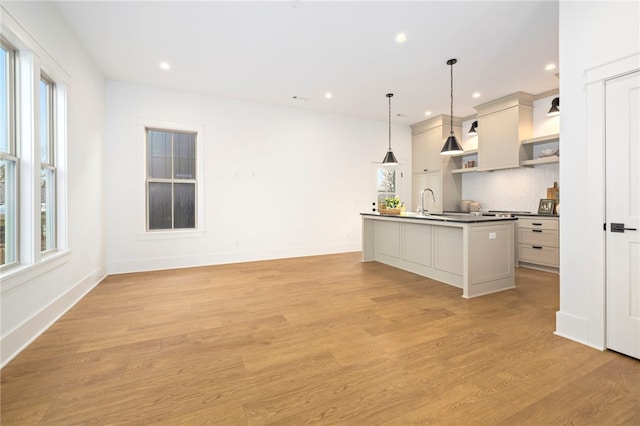 kitchen with open shelves, light wood-style floors, dark countertops, decorative light fixtures, and backsplash