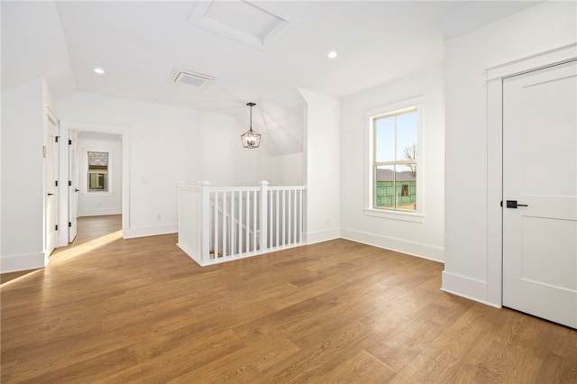 spare room with attic access, recessed lighting, baseboards, and light wood finished floors