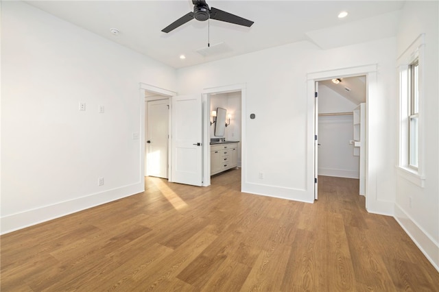 unfurnished bedroom featuring recessed lighting, baseboards, light wood-style floors, and a spacious closet