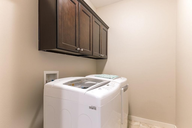 laundry room with independent washer and dryer and cabinets