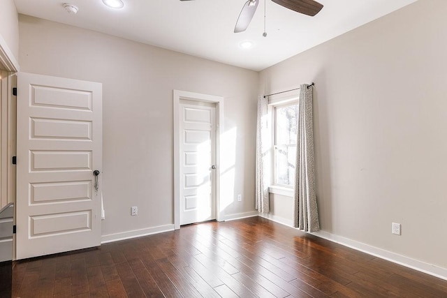 empty room with dark hardwood / wood-style flooring and ceiling fan