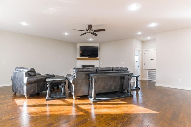 living room featuring hardwood / wood-style flooring, a fireplace, and ceiling fan