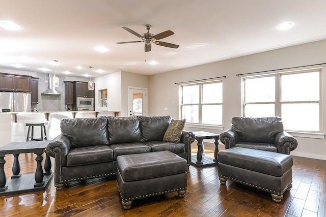 living room featuring dark wood-type flooring and ceiling fan