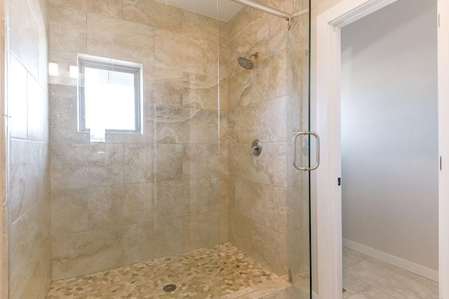 bathroom with an enclosed shower and tile patterned floors