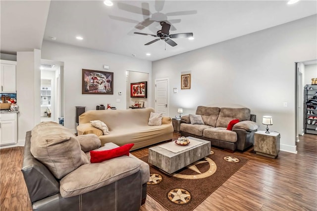 living room featuring ceiling fan and dark hardwood / wood-style floors