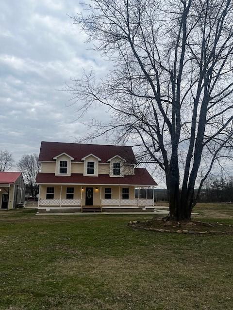 view of front of property featuring covered porch and a front lawn