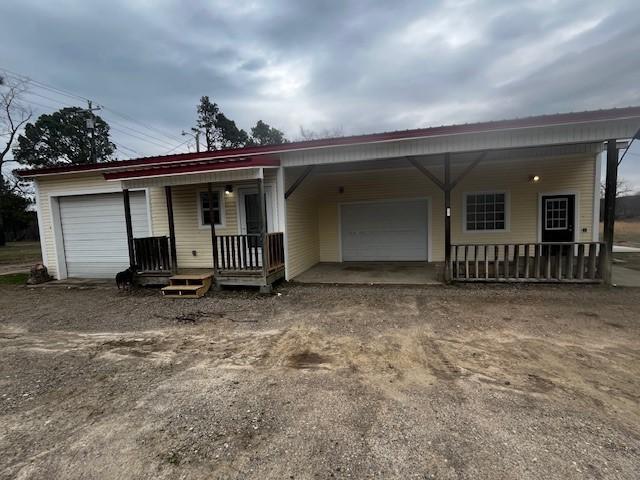 single story home featuring a garage and a porch