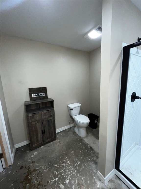 bathroom with baseboards, concrete floors, toilet, and a stall shower