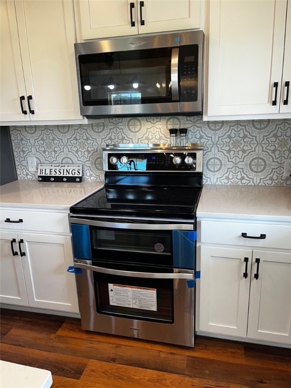 kitchen featuring dark wood-style floors, light countertops, white cabinets, and appliances with stainless steel finishes