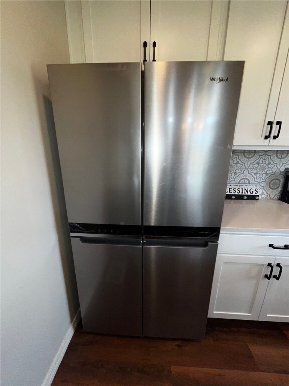 room details featuring light countertops, freestanding refrigerator, white cabinetry, tasteful backsplash, and dark wood-style floors