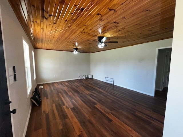 unfurnished room with baseboards, dark wood-style flooring, wood ceiling, and a ceiling fan