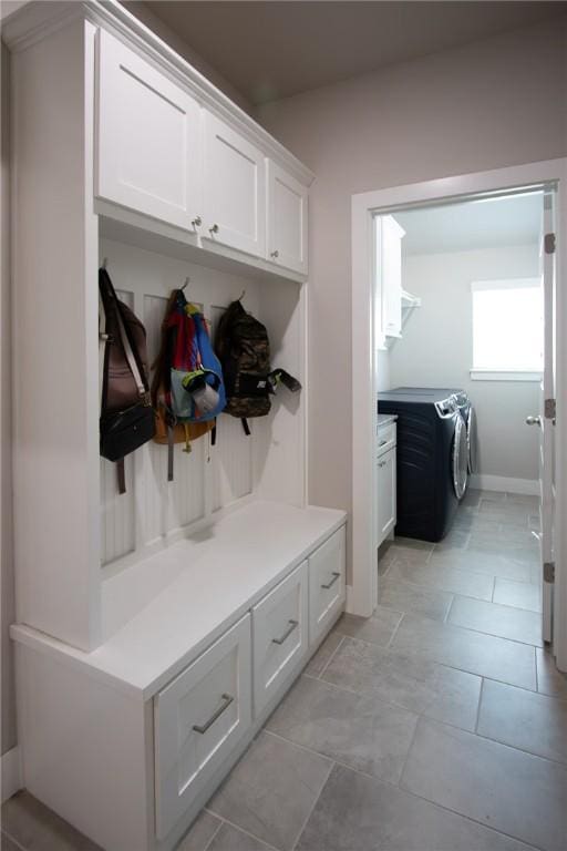 mudroom with light tile patterned floors and independent washer and dryer