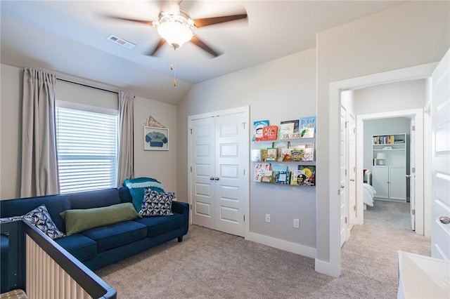 interior space featuring ceiling fan, visible vents, vaulted ceiling, and carpet flooring