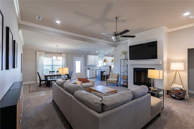 living area with baseboards, a fireplace, visible vents, and crown molding