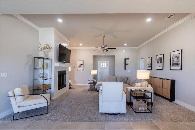 carpeted living room with ornamental molding, a glass covered fireplace, baseboards, and recessed lighting