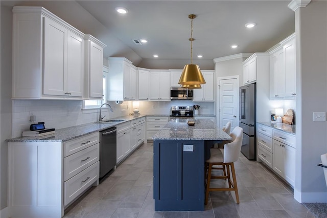 kitchen featuring a kitchen island, white cabinetry, stainless steel appliances, and a sink