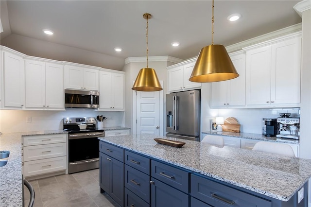 kitchen with appliances with stainless steel finishes, a kitchen island, white cabinetry, and blue cabinets