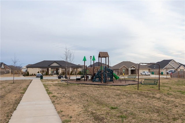 community playground featuring a residential view, a lawn, and fence