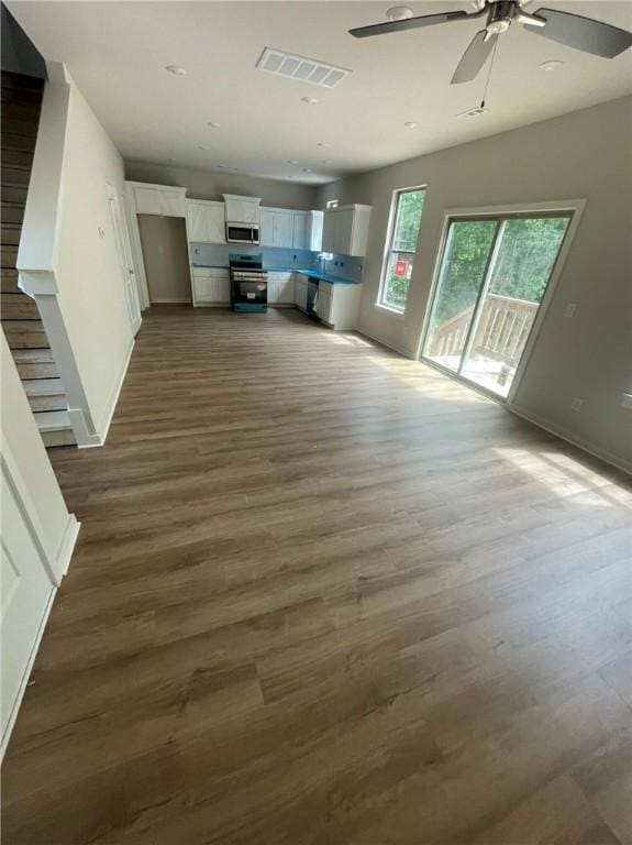 43 Saint Austell Dr, Bella Vista, AR 72714 - unfurnished living room with dark wood-style floors, ceiling fan, baseboards, and recessed lighting