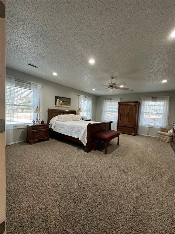 bedroom featuring a textured ceiling, ceiling fan, and carpet