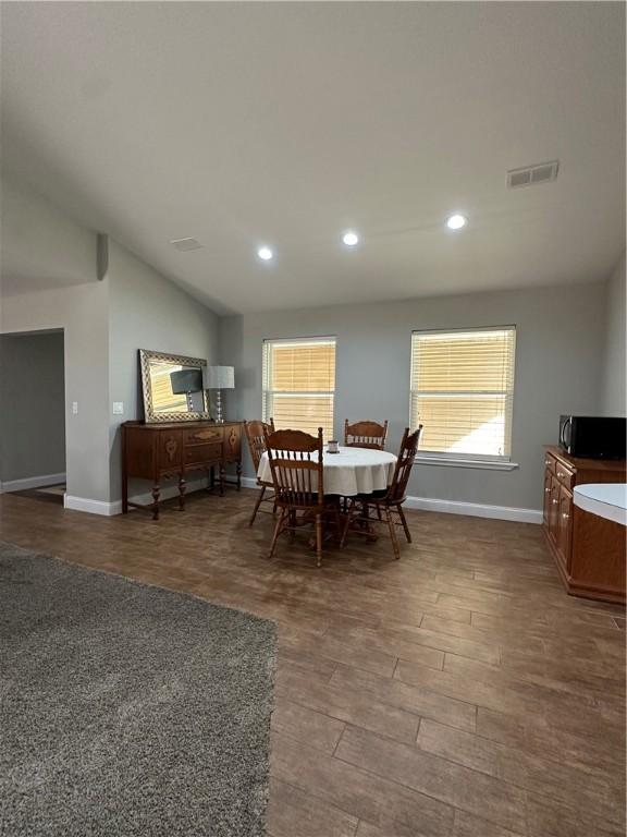 dining room with lofted ceiling and dark hardwood / wood-style flooring