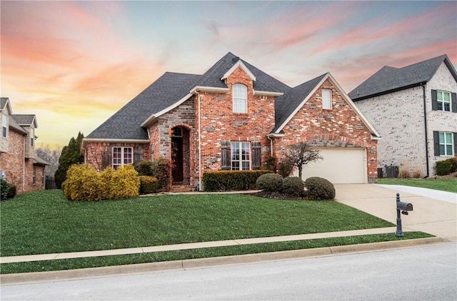 front of property with central AC, a garage, and a yard