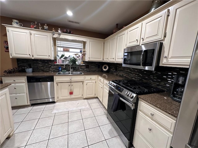 kitchen featuring stainless steel appliances, sink, white cabinets, and decorative backsplash