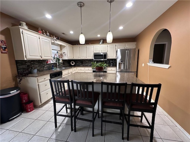 kitchen featuring stainless steel appliances, sink, white cabinets, and dark stone counters