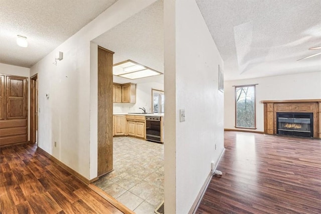 hallway featuring hardwood / wood-style flooring, sink, and a textured ceiling