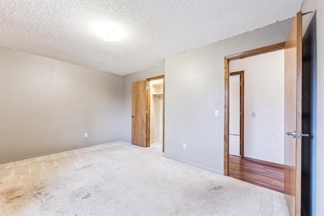 empty room with light colored carpet and a textured ceiling