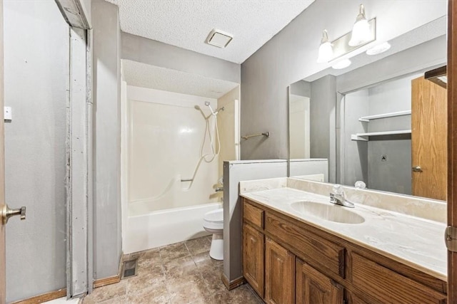 full bathroom with vanity, tub / shower combination, toilet, and a textured ceiling