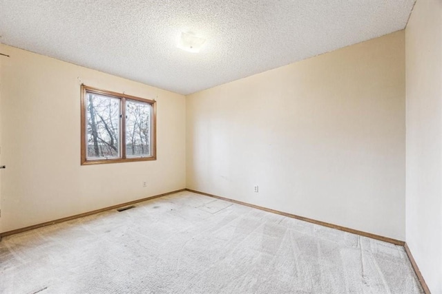 carpeted spare room featuring a textured ceiling