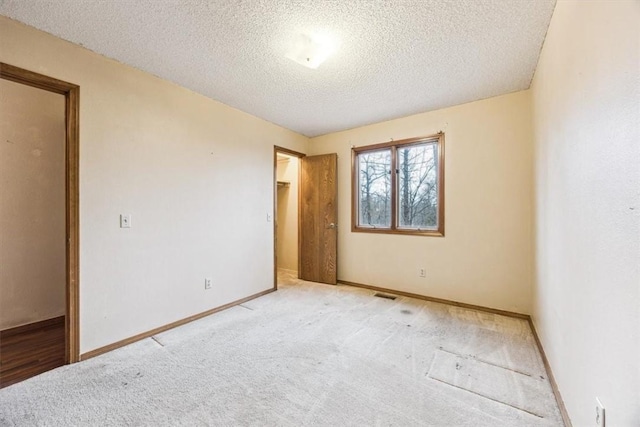 unfurnished bedroom featuring light colored carpet and a textured ceiling