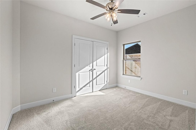 empty room featuring light colored carpet and ceiling fan