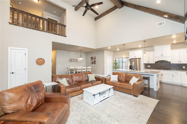 living room featuring ceiling fan, hardwood / wood-style flooring, high vaulted ceiling, and beamed ceiling