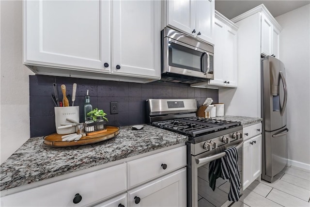 kitchen with tasteful backsplash, light stone counters, light tile patterned flooring, white cabinets, and stainless steel appliances