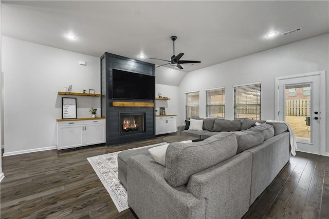 living area with visible vents, a fireplace, ceiling fan, and dark wood-style flooring