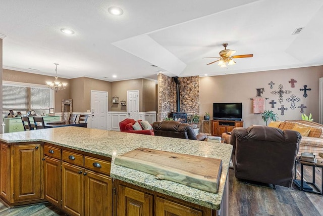 kitchen featuring hanging light fixtures, a center island, a wood stove, and dark hardwood / wood-style floors