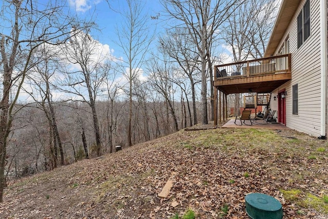 view of yard featuring a patio and a wooden deck